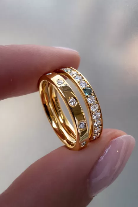 Two Stacking Rings in 18ct Yellow Gold, one flush set with spaced out diamond and one with grain set diamonds, aquamarine and topaz.