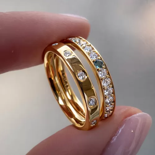 Two Stacking Rings in 18ct Yellow Gold, one flush set with spaced out diamond and one with grain set diamonds, aquamarine and topaz.
