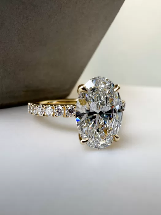 Bespoke oval diamond engagement ring on table