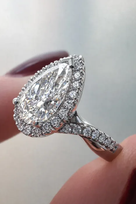 Custom Pear Cut Diamond Halo Engagement Ring between fingers