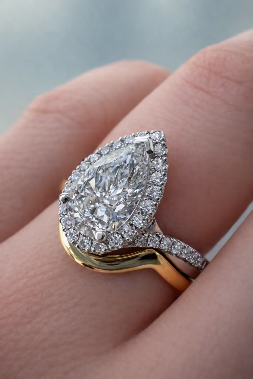 Custom Pear Cut Diamond Halo Engagement Ring Custom Pear Cut Diamond Halo Engagement Ring on hand with gold wedding ring