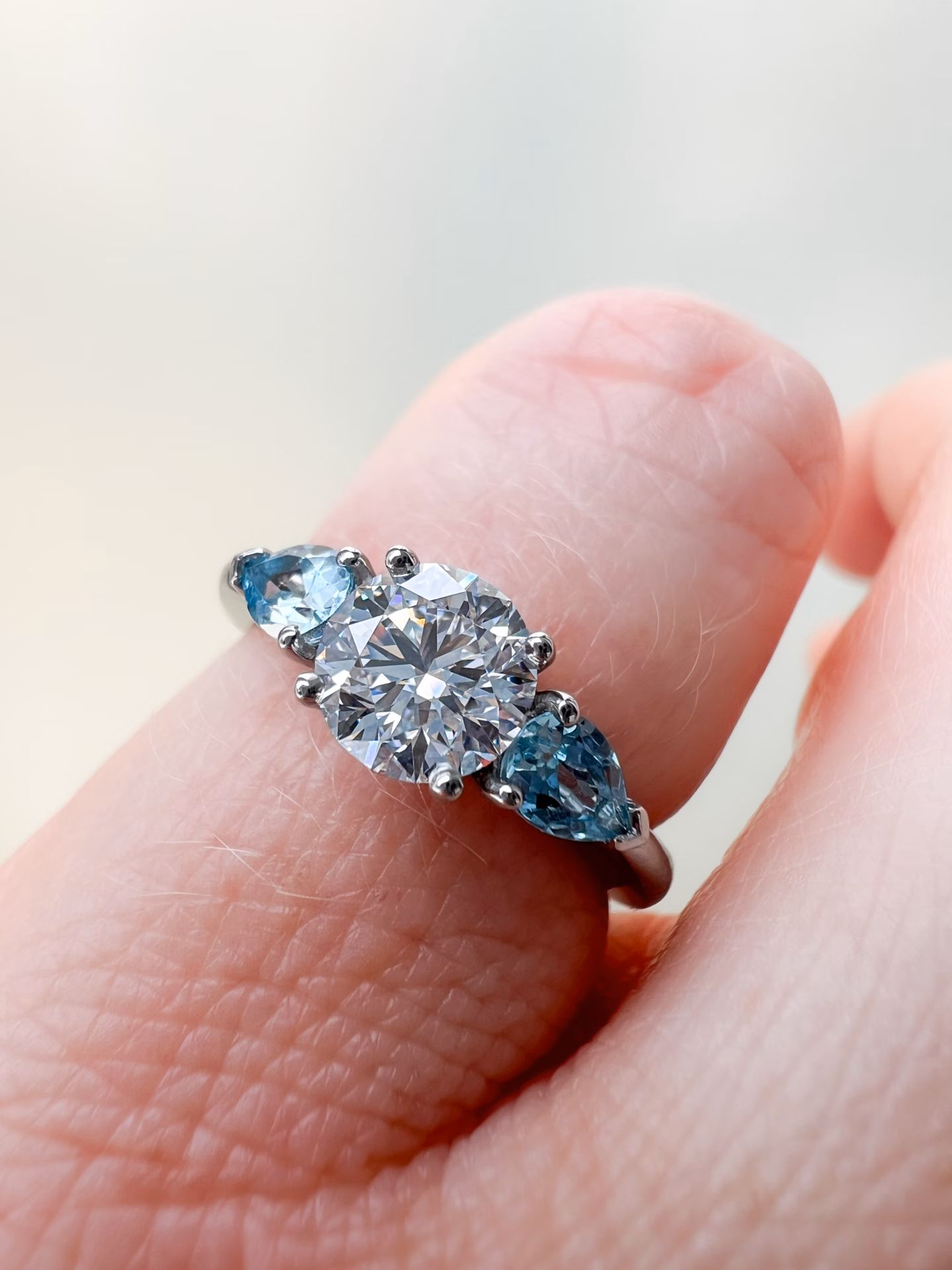 Diamond and Aquamarine Three Stone Engagement Ring on hand
